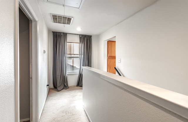 hallway featuring light colored carpet