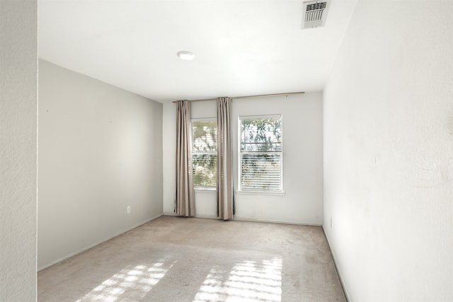 spare room featuring light carpet