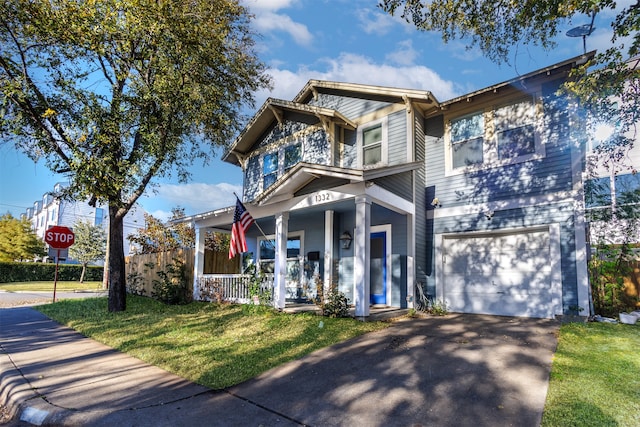 view of front facade featuring covered porch, a garage, and a front lawn