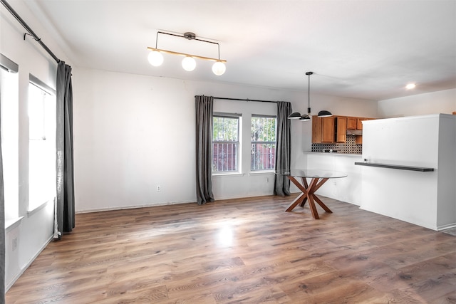 kitchen with backsplash, decorative light fixtures, and dark wood-type flooring