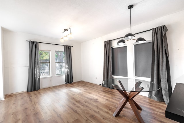 unfurnished dining area with hardwood / wood-style floors and a textured ceiling