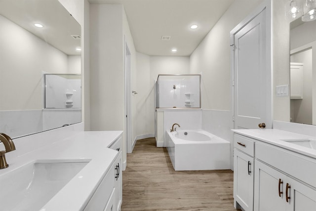 bathroom featuring plus walk in shower, hardwood / wood-style floors, and vanity