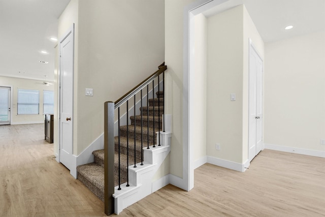 stairway featuring hardwood / wood-style flooring and ceiling fan