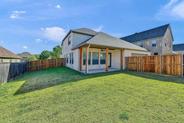 rear view of property featuring a yard, a patio, and ceiling fan