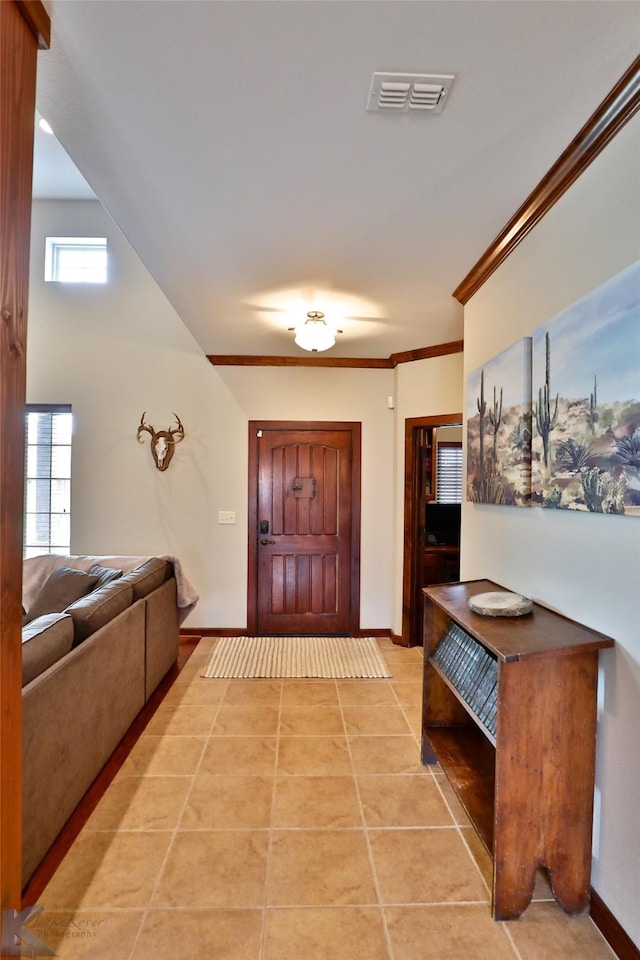 tiled entrance foyer featuring crown molding