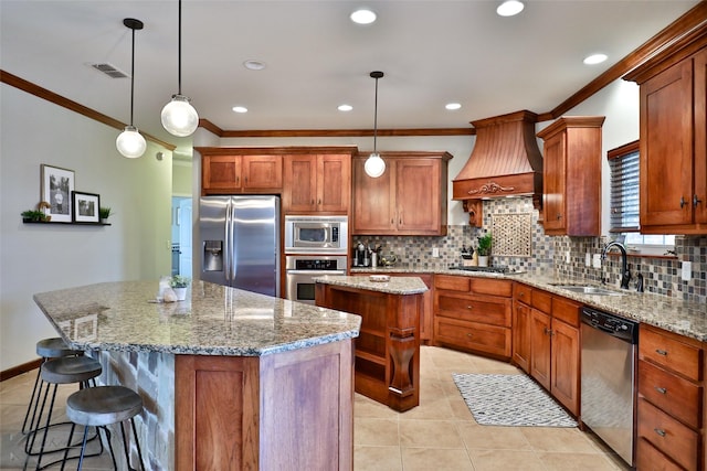 kitchen with appliances with stainless steel finishes, decorative light fixtures, a kitchen island, and custom exhaust hood