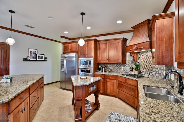 kitchen with appliances with stainless steel finishes, light stone counters, sink, decorative light fixtures, and a center island