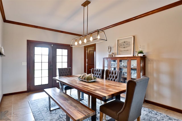 dining room featuring light tile patterned floors, crown molding, and french doors