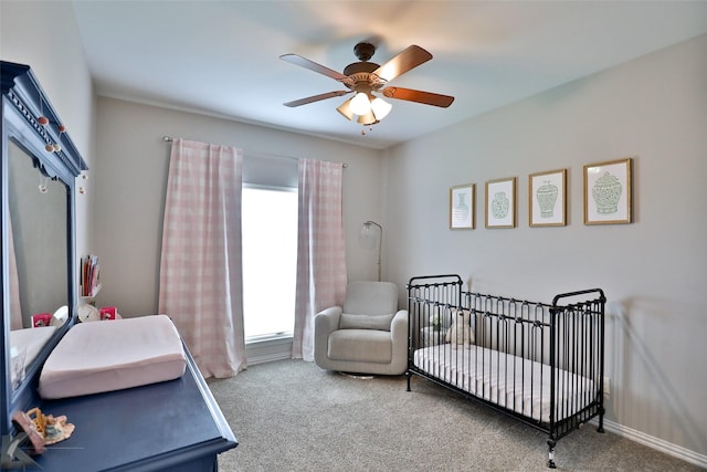 carpeted bedroom with a nursery area and ceiling fan