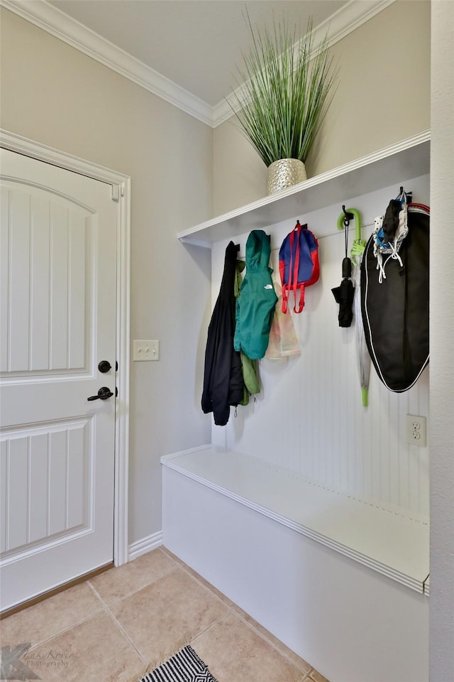 mudroom with light tile patterned floors and ornamental molding