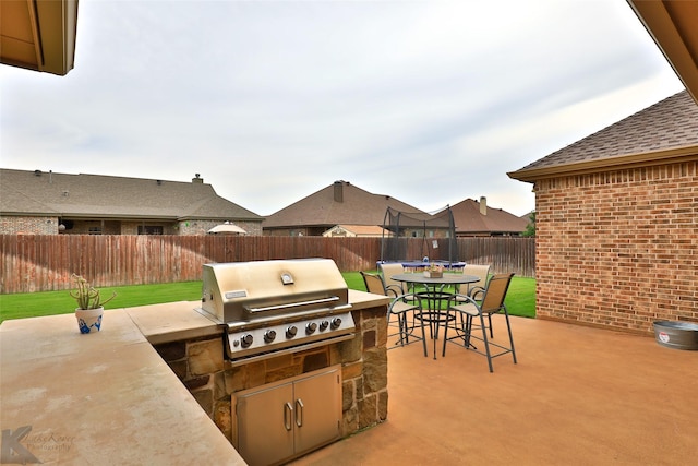 view of patio / terrace with a trampoline, exterior kitchen, and a grill