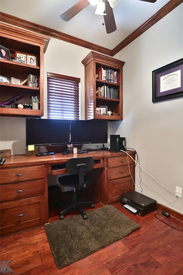 home office featuring crown molding, built in desk, ceiling fan, and dark wood-type flooring