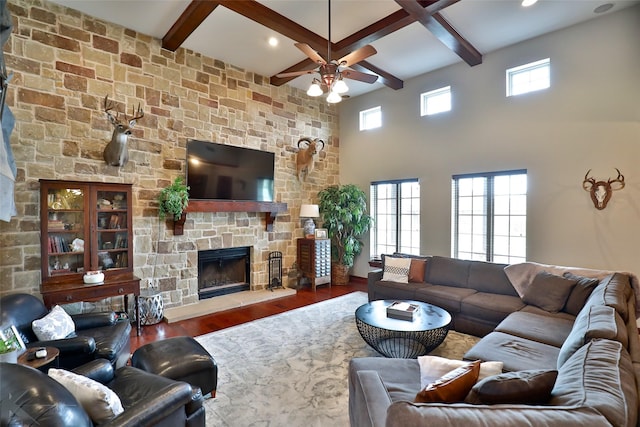 living room featuring beam ceiling, dark hardwood / wood-style flooring, and a wealth of natural light