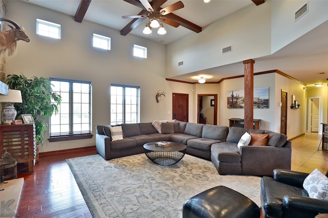 living room with beam ceiling, ceiling fan, a high ceiling, decorative columns, and hardwood / wood-style flooring