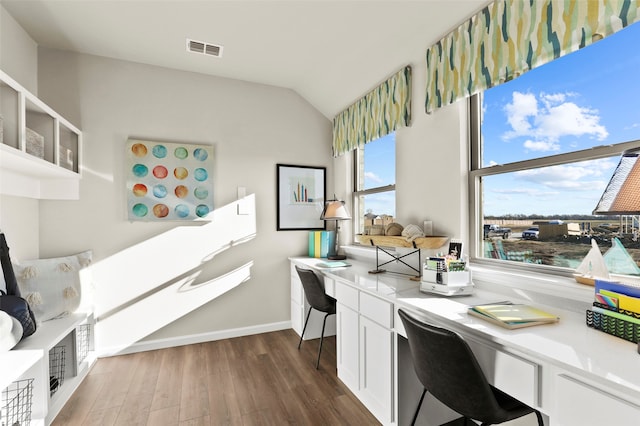 office featuring dark hardwood / wood-style floors, a healthy amount of sunlight, built in desk, and vaulted ceiling