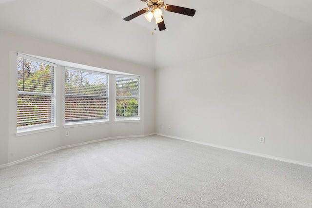 carpeted empty room featuring plenty of natural light, ceiling fan, and vaulted ceiling