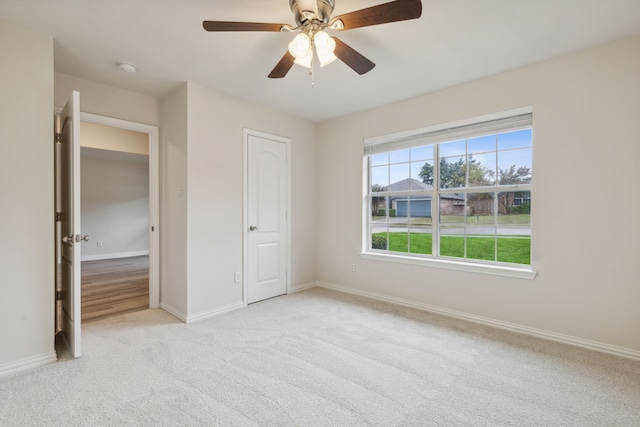 unfurnished bedroom with ceiling fan, light colored carpet, and a closet