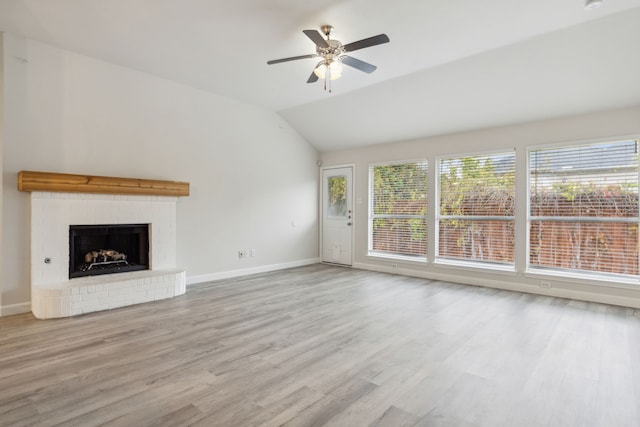 unfurnished living room with ceiling fan, light hardwood / wood-style floors, lofted ceiling, and a fireplace