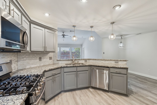 kitchen with ceiling fan, decorative light fixtures, vaulted ceiling, appliances with stainless steel finishes, and light wood-type flooring