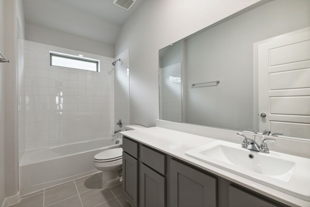 full bathroom with tiled shower / bath, tile patterned floors, toilet, and vanity