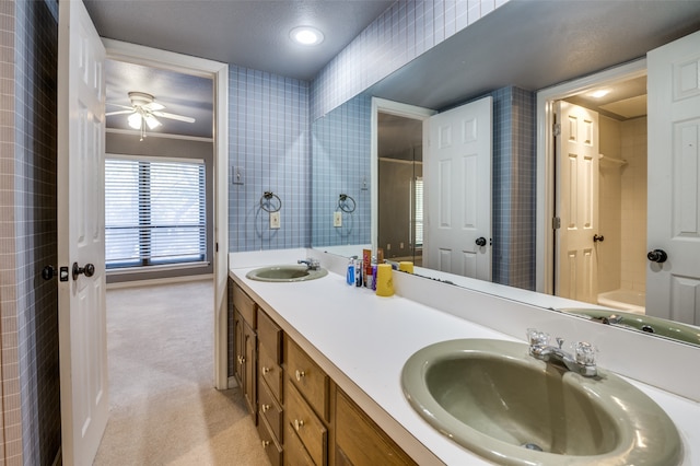 bathroom with a textured ceiling, vanity, ceiling fan, and crown molding