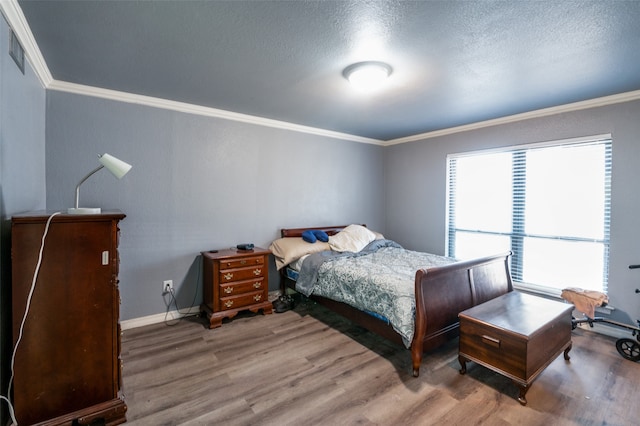 bedroom with wood-type flooring, a textured ceiling, and ornamental molding