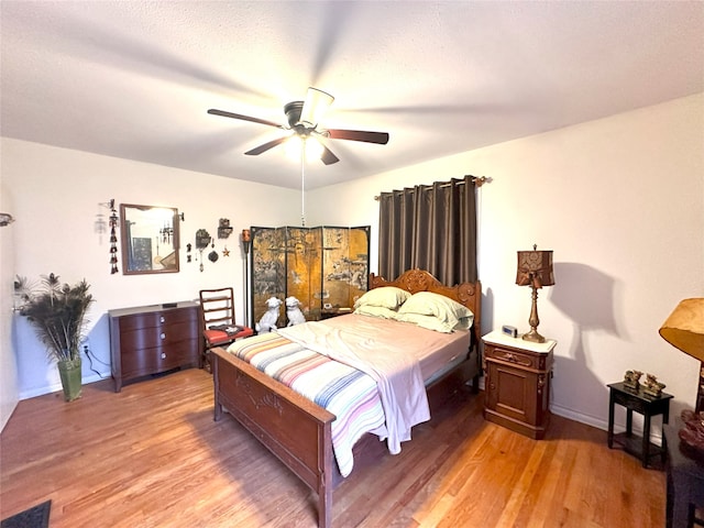 bedroom with ceiling fan and hardwood / wood-style floors