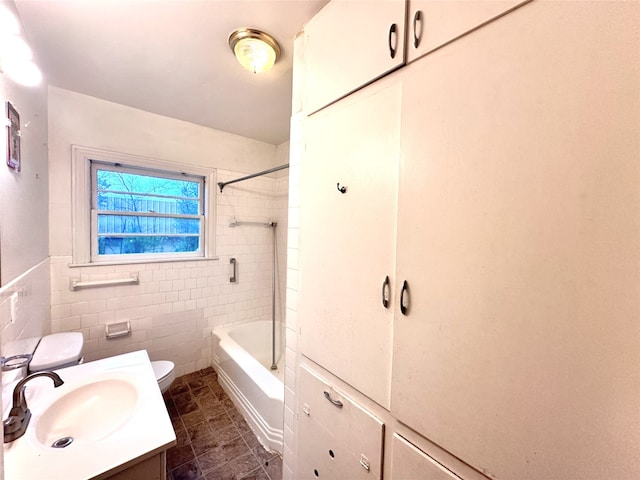 full bathroom with tiled shower / bath combo, vanity, tile walls, and toilet