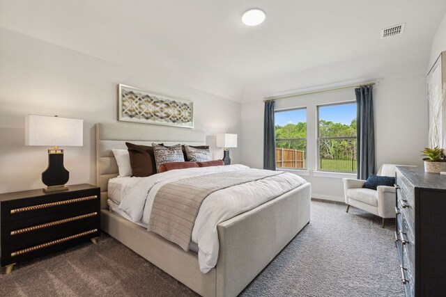 bedroom with dark colored carpet and vaulted ceiling