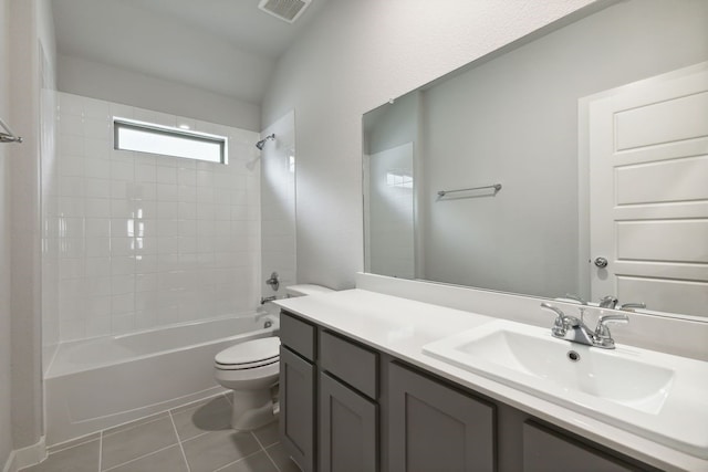 full bathroom with tile patterned flooring, tiled shower / bath combo, toilet, and vanity