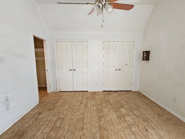 unfurnished bedroom featuring multiple closets, ceiling fan, light hardwood / wood-style floors, and lofted ceiling