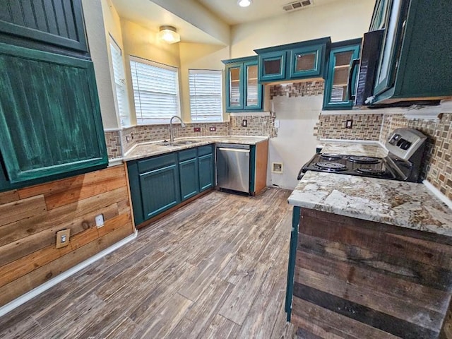 kitchen featuring tasteful backsplash, sink, stainless steel appliances, and light hardwood / wood-style floors