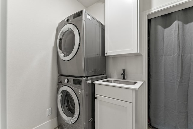 laundry room with cabinets, sink, and stacked washer and dryer