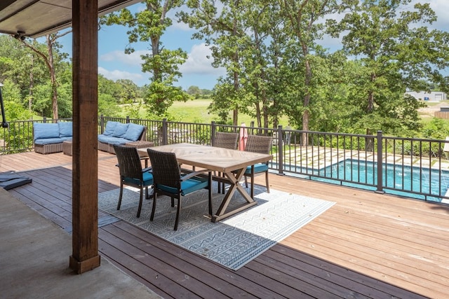 wooden deck with outdoor lounge area and a fenced in pool