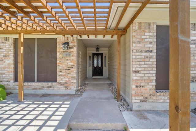 view of exterior entry with a pergola