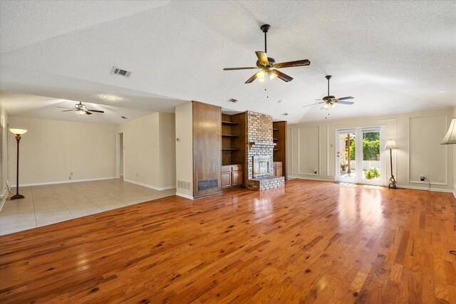 unfurnished living room featuring ceiling fan, a textured ceiling, and light hardwood / wood-style flooring