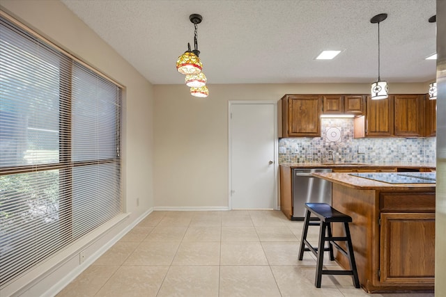 kitchen featuring dishwasher, a kitchen breakfast bar, hanging light fixtures, and tasteful backsplash