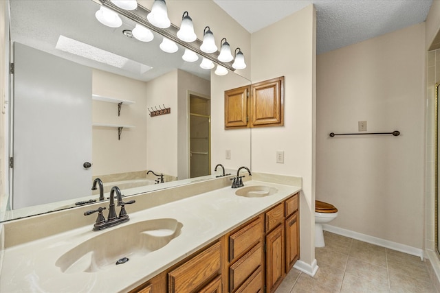 full bathroom featuring a skylight, tile patterned floors, a textured ceiling, toilet, and vanity