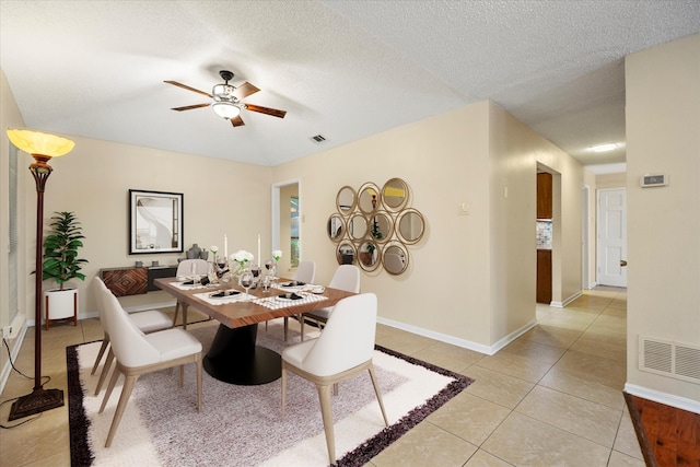 tiled dining area featuring a textured ceiling and ceiling fan