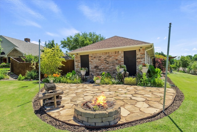 rear view of house with a lawn, a patio area, and an outdoor fire pit