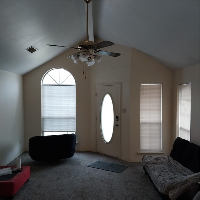 foyer entrance featuring ceiling fan, carpet flooring, and vaulted ceiling