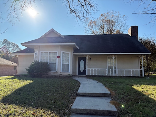 ranch-style home featuring covered porch and a front lawn