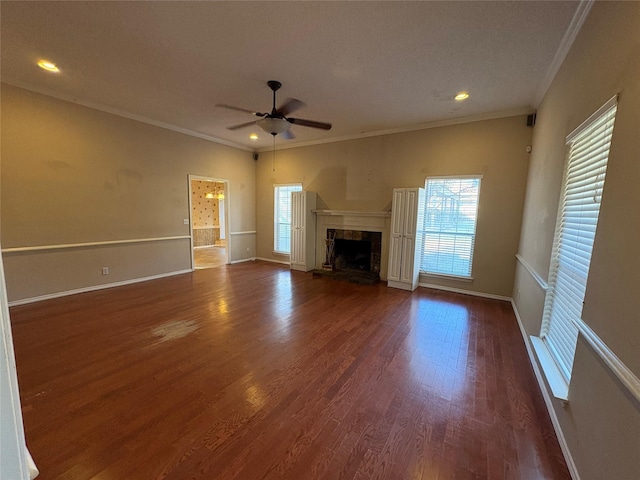 unfurnished living room with a premium fireplace, dark wood-type flooring, ceiling fan, and crown molding