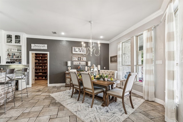 dining space with ornamental molding and a chandelier