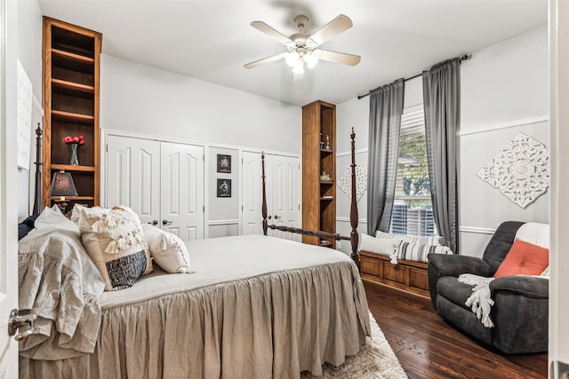 bedroom with ceiling fan, dark wood-type flooring, and multiple closets