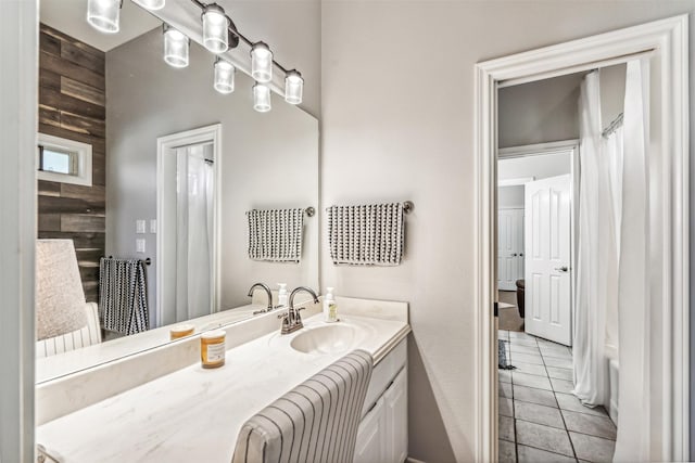 bathroom with tile patterned flooring, vanity, and wooden walls