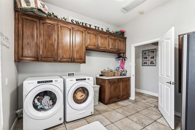 laundry area featuring cabinets, light tile patterned flooring, and independent washer and dryer