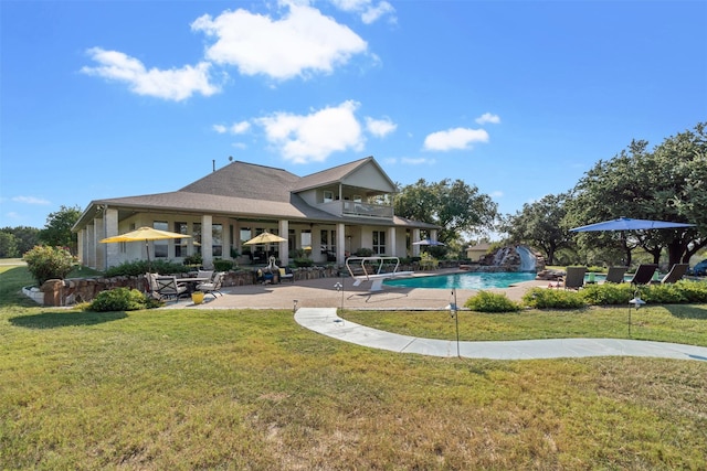 view of swimming pool with pool water feature, a patio area, and a lawn