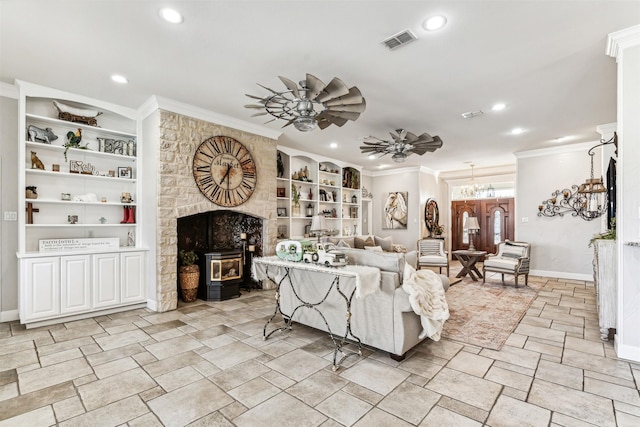 living room with ornamental molding, a wood stove, ceiling fan, and built in shelves