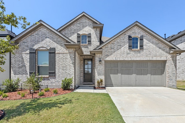 view of front of property featuring a garage and a front lawn